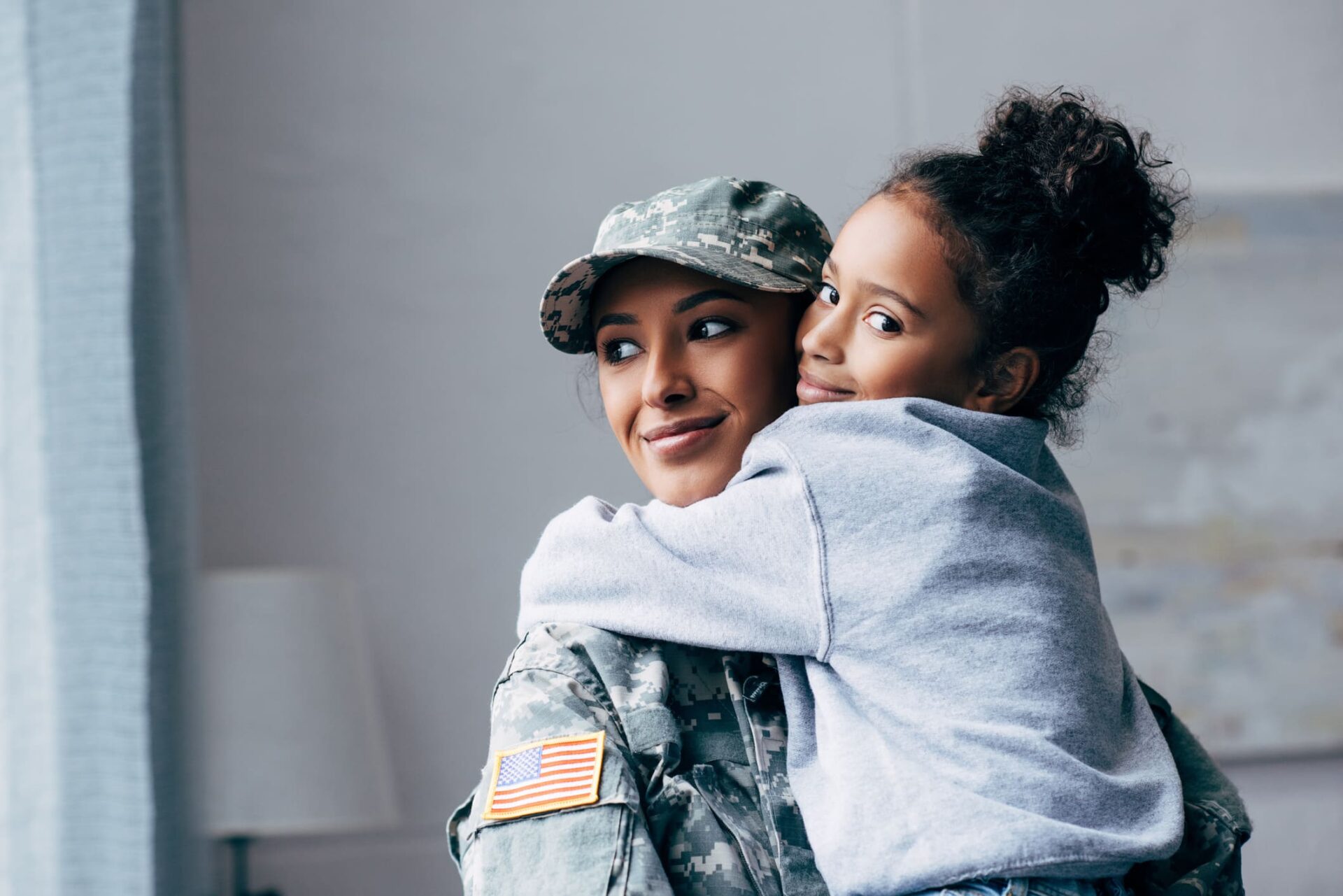 military girl hugging a little girl