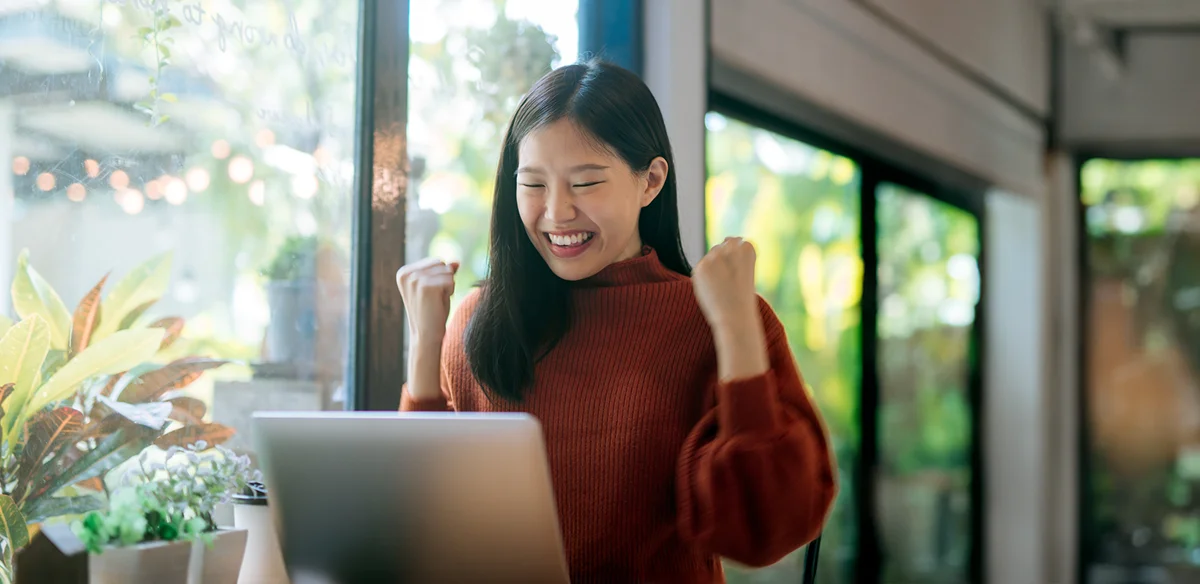 Student attending to an online class wearing a red sweater